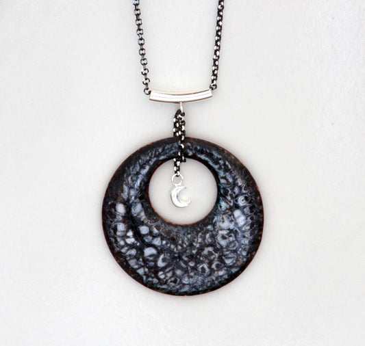 Round black gray and white enamel pendant necklace with quarter moon hanging in the center. Hung from a silver bail and chain.