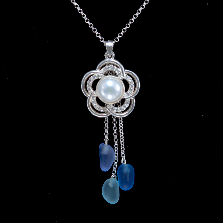 Silver flower pendant with cubic zirconia and white pearl. Blue, teal and purple beach glass hang on silver dangle chains