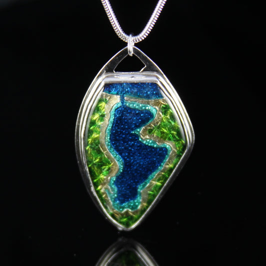 Enamel pendant of Portage Lake in Onekama, Michigan. Pendant is set in fine silver.
