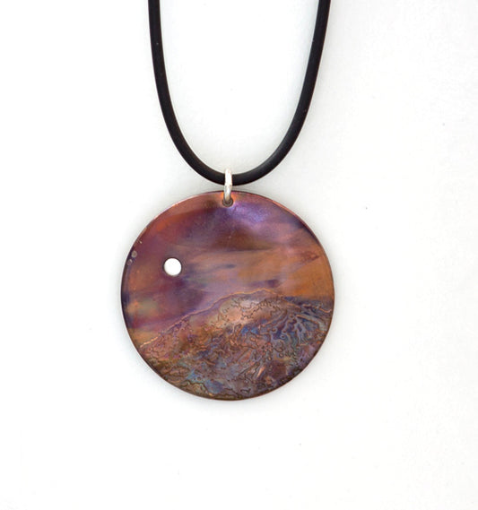 Serenity is a flame painted copper pendant necklace with etched mountain and fine silver moon in the sky
