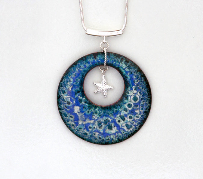 Blue, teal, white, black round enamel pendant with beach theme and starfish. Silver tube bail hung from silver chain