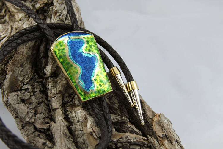 portage lake enamel bolo tie with black braided leather cord, set in gold