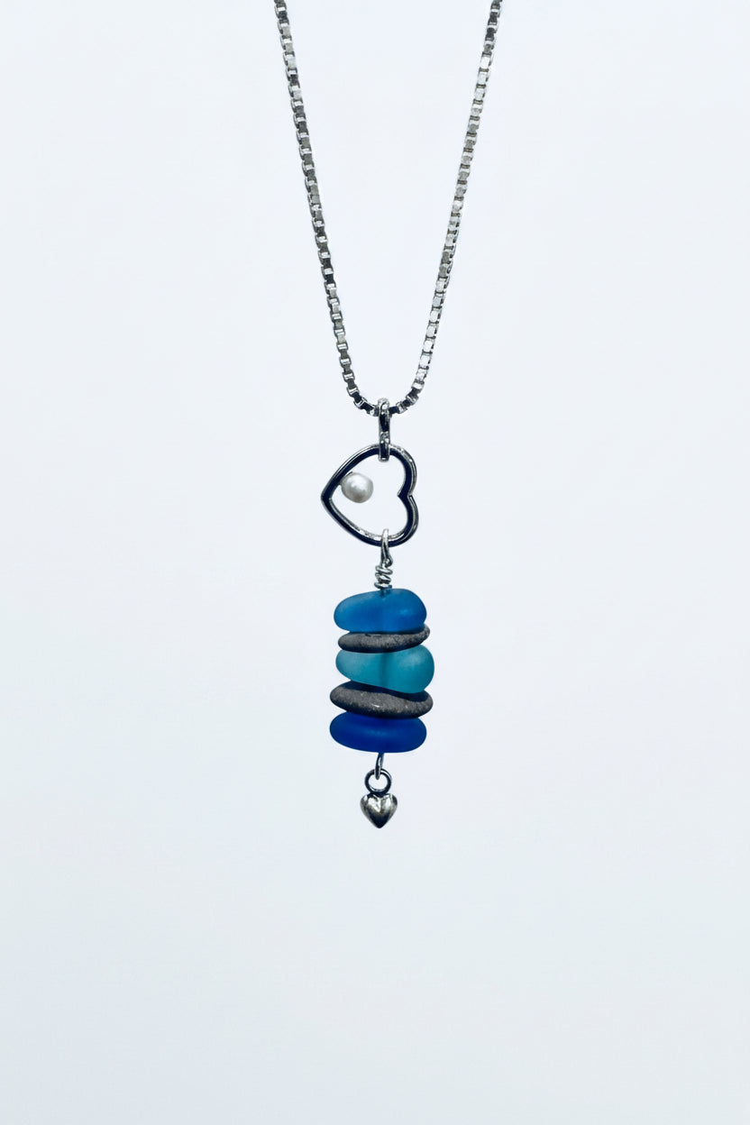 Beach theme necklace with beach stones, glass, pearl, heart charm on white background