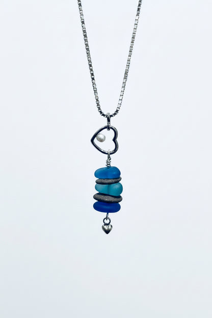 Beach theme necklace with beach stones, glass, pearl, heart charm on white background
