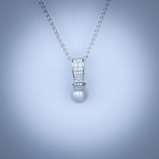 Single white freshwater pearl pendant with cubic zirconia on sterling silver bail. Hung on sterling silver chain